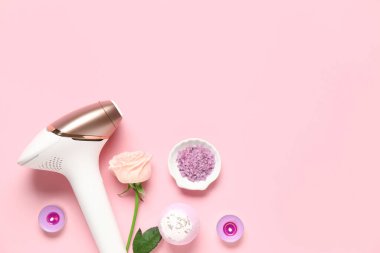 Banyo malzemeleri, mumlar ve pembe arka planda gül çiçekli modern fotoepilatör.