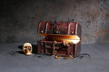 Hazine sandığı ve karanlık arka planda Cadılar Bayramı dekoru.