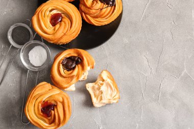 Gri arka planda çikolata ve reçelli lezzetli kabuklar.