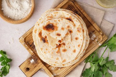 Tahta tahtada beyaz arka planda lezzetli pita ekmeği ve un