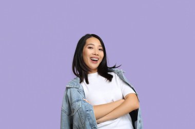 Genç Asyalı kadın leylak arka planda gülüyor