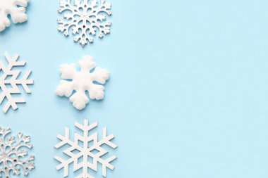 Mavi arka planda birçok Noel dekoratif kar taneleri