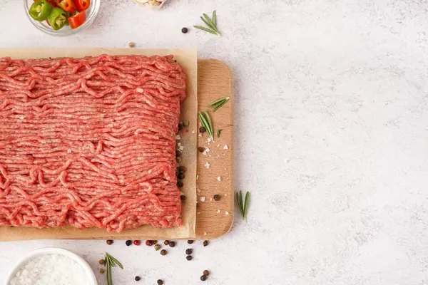 Beyaz arka planda baharatlı taze kıyma tahtası.