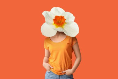 Turuncu arka planda kafası yerine narsistli genç bir kadın.