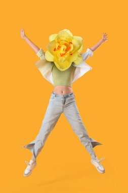 Sarı arka planda atlayan genç bir kadın