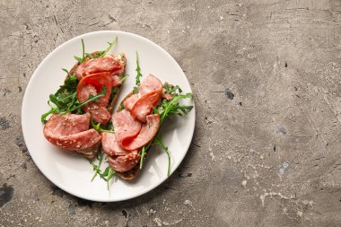 Bir tabak lezzetli bruschetta ve arkaplanda jambon.