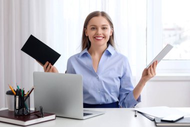 Ofisinde not defteri ve tablet bilgisayarı olan genç bir iş kadını. Denge kavramı