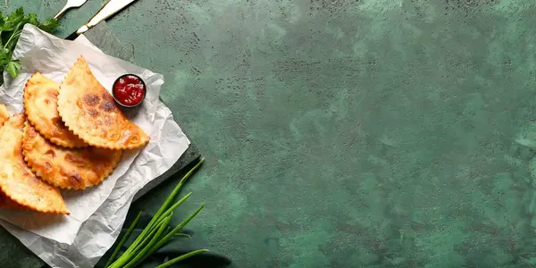 Yeşil grunge arkaplan üzerinde lezzetli chebureks ve sos metin için yer ile