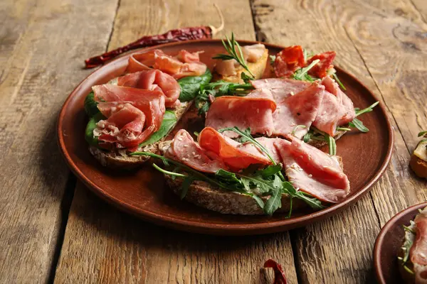 Ahşap arka planda jambonlu lezzetli bruschetalar.