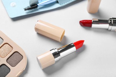 Işıklı arka planda güzel ruj ve göz farı, yakın plan.