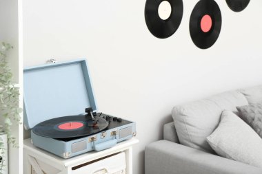 Oturma odasındaki rafta vinil diski olan kayıt çalar