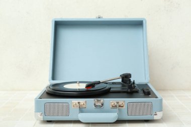 Işık duvarının yanındaki masada vinil diski olan kayıt çalar