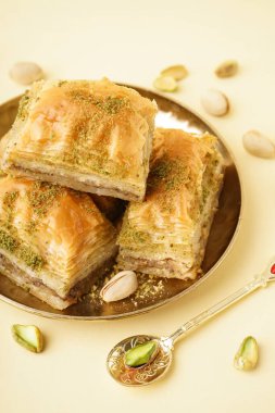 Sarı arka planda lezzetli baklava tabağı, yakın plan.