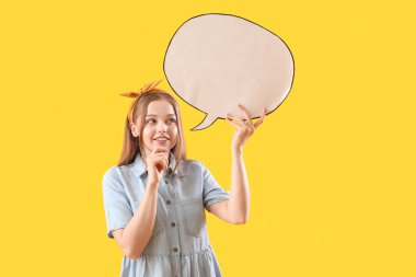 Sarı arka planda boş konuşma balonu olan düşünceli genç bir kadın.