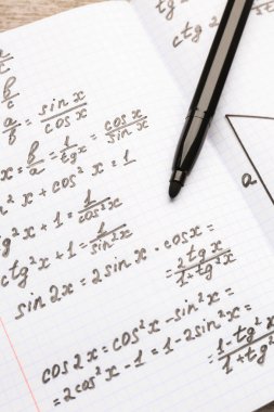 Matematik formülleri ve kalemi olan kitapçık, kapat