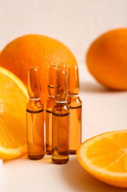 C vitamini ve beyaz arka planda portakal dilimleri olan ampuller.