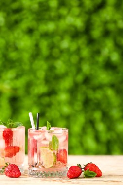 Beyaz ahşap masada çilekli limonata bardakları