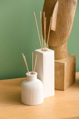 Renk duvarının yakınındaki masada sazlık ayırıcı şişeler, yakın plan.