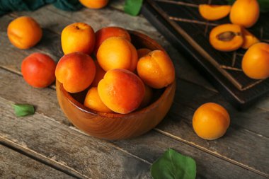 Ahşap masa üzerinde taze kayısı ile kase