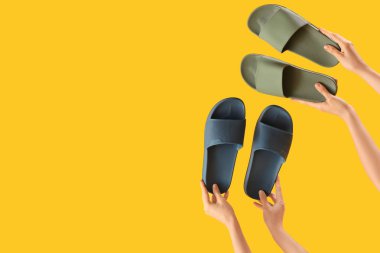 Sarı arka planda parmak arası terlikleri olan eller