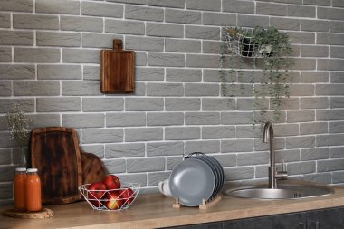 Modern mutfakta lavabosu, elması ve tabağı olan ahşap tezgah.