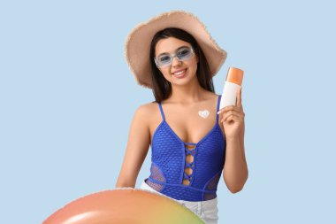 Güneş kremi sürmüş ve yüzme yüzüklü güzel bir genç kadın.