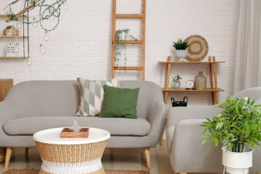 Oturma odasında rahat bir koltuk, kanepe ve masa.