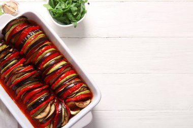 Beyaz ahşap arka planda lezzetli Ratatouille yemeği pişirmek.