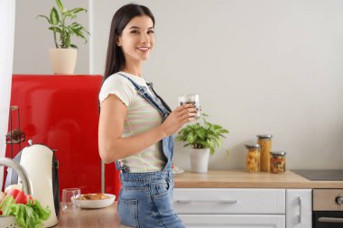 Mutfakta bir fincan sıcak kahveyle genç bir kadın.