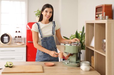 Genç bayan mutfakta kahve yapıyor.