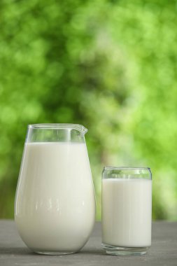 Dışarıdaki gri masada bir bardak taze süt.