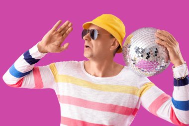 Mor arka planda disko topu olan havalı olgun bir adam.