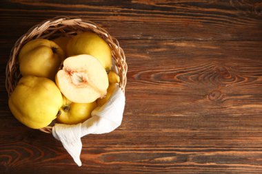 Ahşap arka planda tatlı olgun bıldırcınlar olan hasır kase.