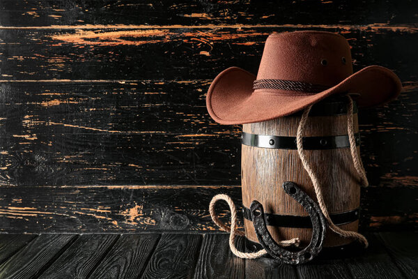 Cowboy hat, lasso and horseshoe on wooden background