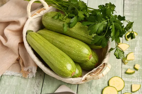 Yeşil ahşap arka planda bir sürü taze kabak ve maydanoz.