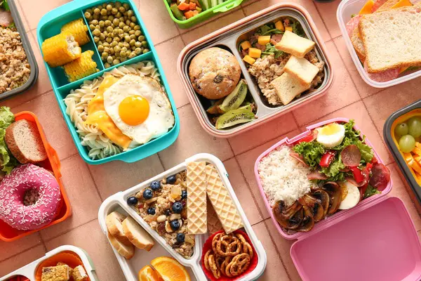 Pembe fayanslı farklı lezzetli yemekleri olan bir sürü beslenme çantası.
