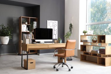 Çalışma yeri ve raf üniteleri olan modern ofisin içi