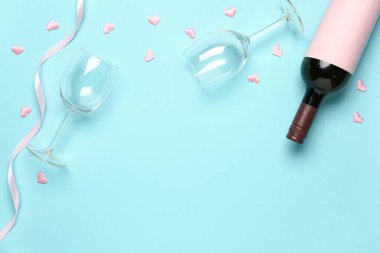 Mavi arka planda Sevgililer Günü için şarap ve gözlüklü kompozisyon