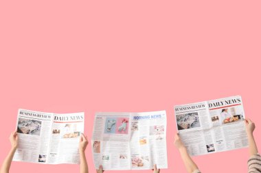 Pembe arka planda gazeteleri olan kadınlar