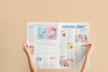Bej arka planda gazetesi olan kadın.