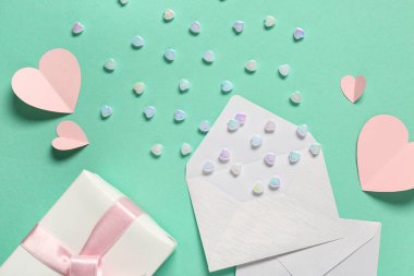 Zarflı kompozisyon, hediye kutusu ve renk arka planında kalp şeklinde cam taşlar. Sevgililer Günü kutlaması