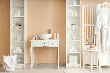 Lavabosu ve raf üniteleri olan şık bir banyo.