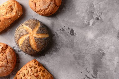 Gri grunge arka planında farklı taze çörekler.