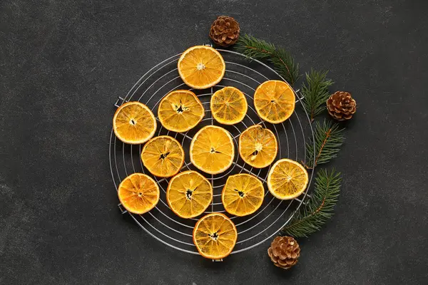 Kurumuş portakal dilimlerinin yanında çam kozalakları ve köknar dalları.