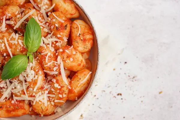 Beyaz arka planda peynirli bir kase lezzetli gnocchi