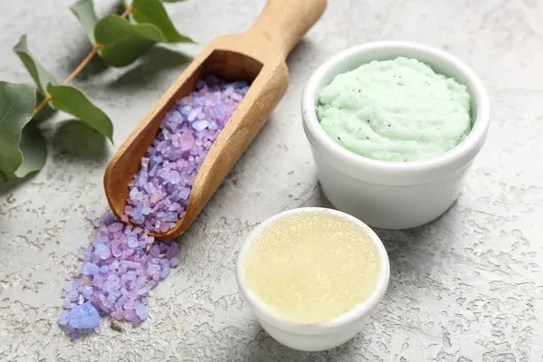 Arka planda vücut önlüğü, deniz tuzu ve okaliptüs dalları olan kaseler.