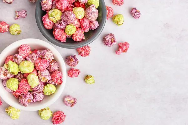 Beyaz arka planda tatlı renkli patlamış mısır kaseleri