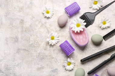 Papatyalı kuaför aksesuarları ve gri grunge arka planda Paskalya yumurtaları.