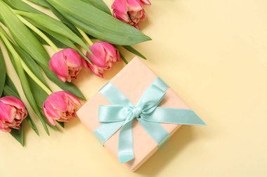 Hediye kutusu ve sarı arka planda güzel laleler. Uluslararası Kadınlar Günü