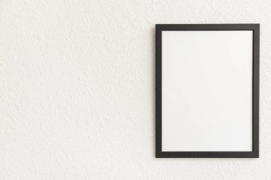Işık duvarında boş siyah fotoğraf çerçevesi